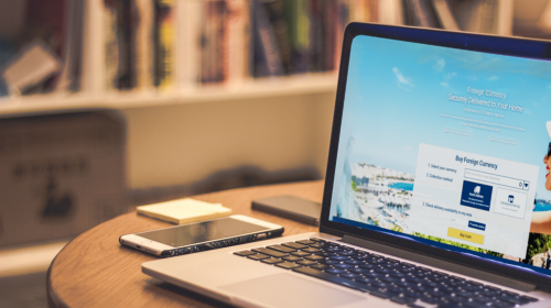 Traveler comparing currency exchange options at a laptop