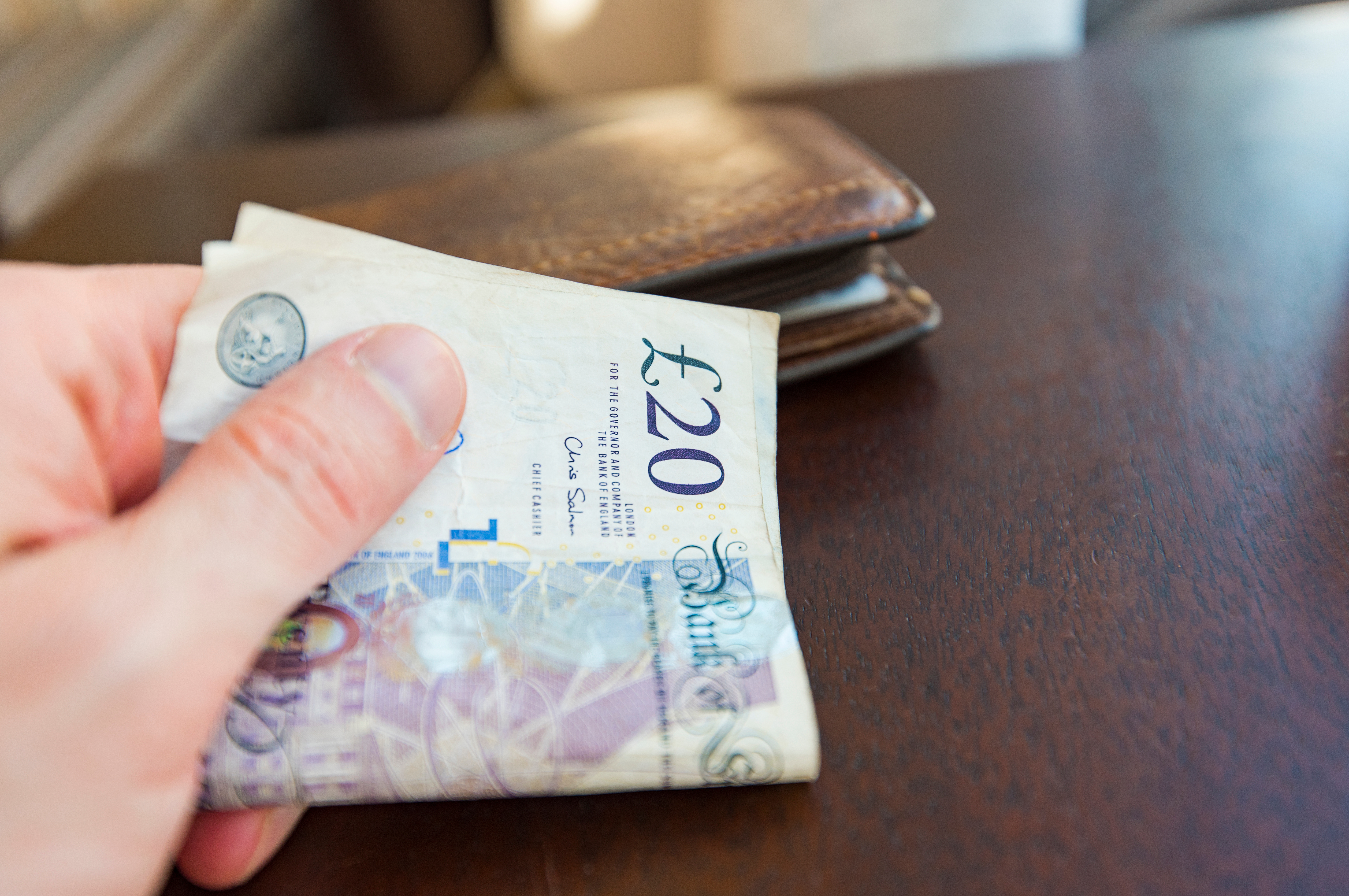 Man paying by 20 pound notes at cafe or shop in London