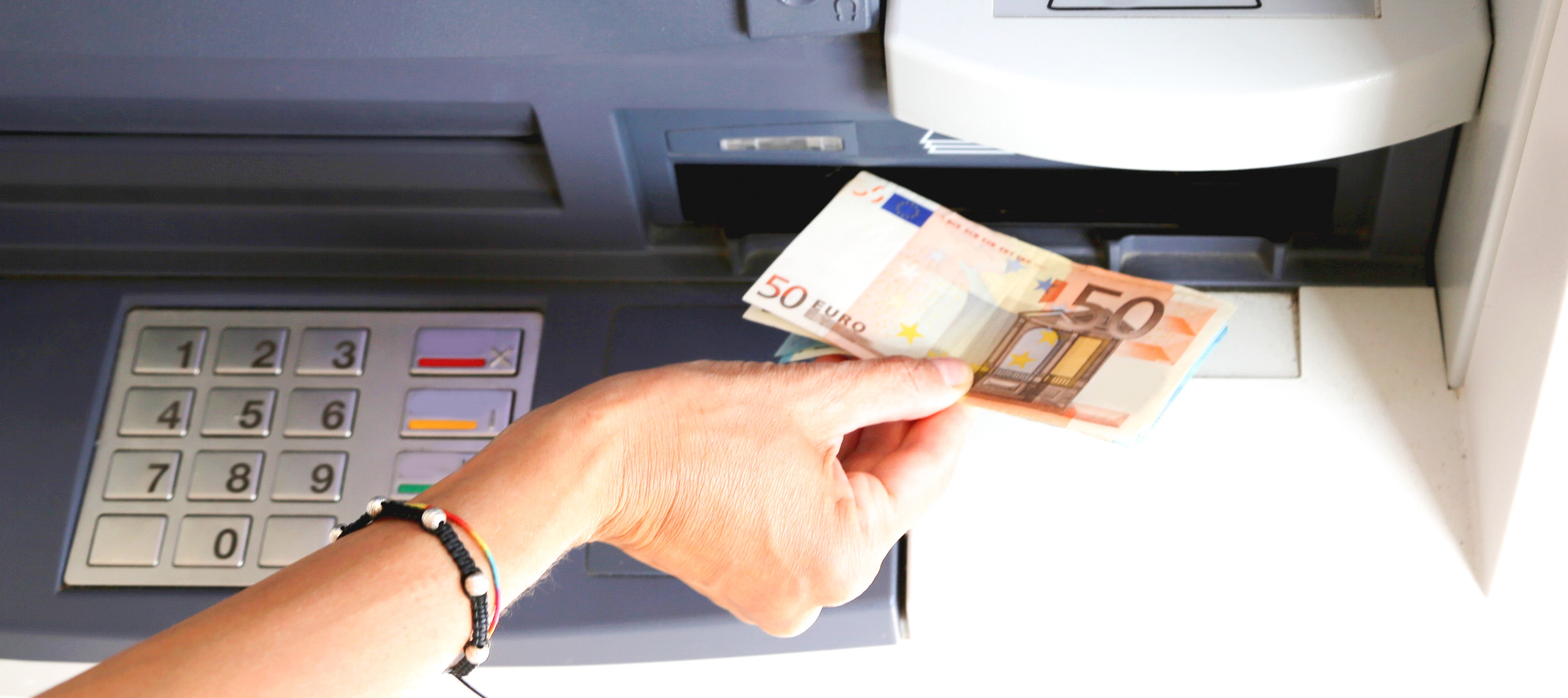 Woman withdrawing 50 euros from an ATM