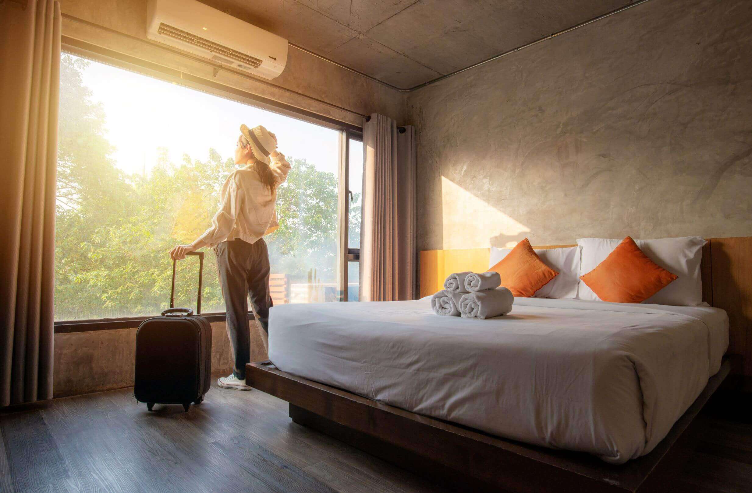 Tourist woman with her luggage in hotel bedroom