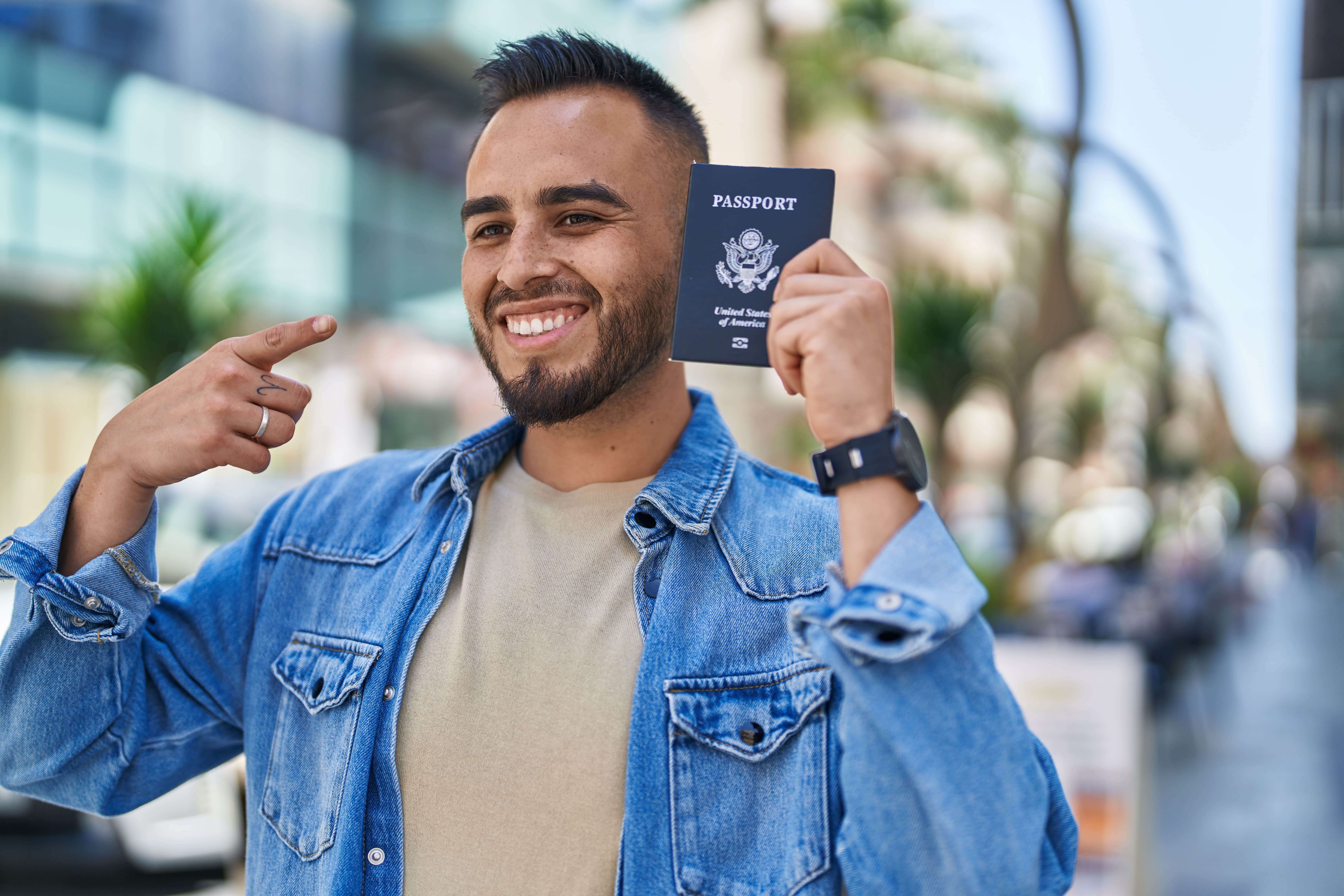 Young man smiling confident holding passport at street